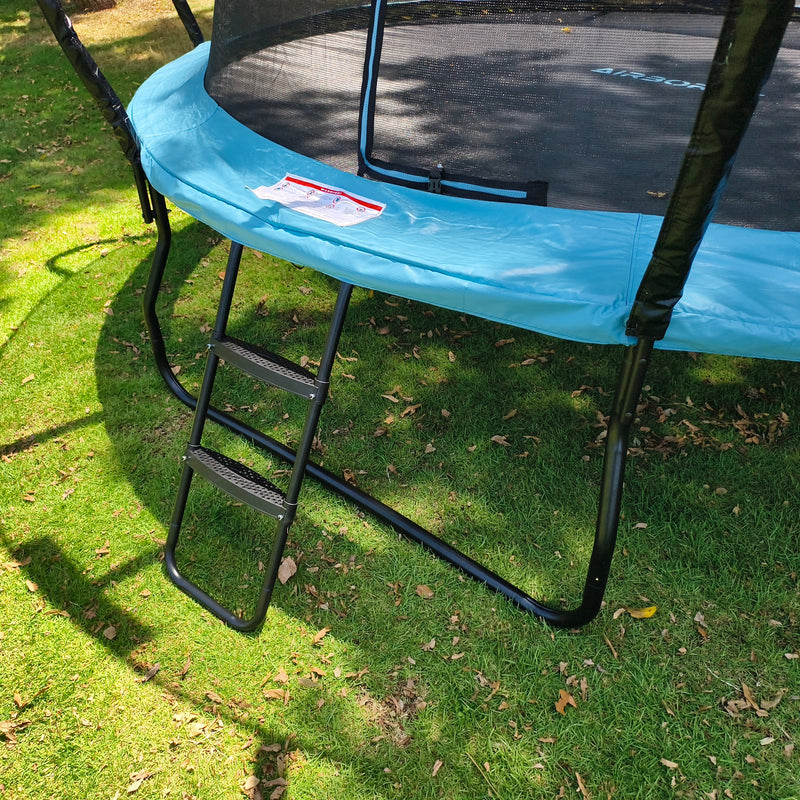 Blue trampoline with a ladder on a grassy area
